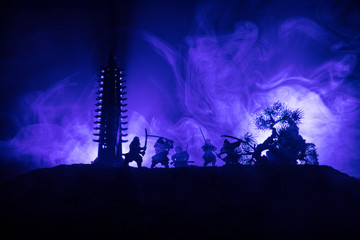 Samurai fighting concept. Silhouette of samurais in duel near tree and old temple. Picture with two...