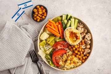 Buddha bowl with vegetables, mushrooms, bulgur, hummus and baked chickpeas. White background, top view. Israeli food concept.