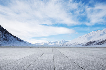 empty brick ground with snow mountain