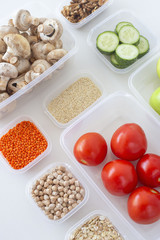 Storage of vegetarian food in plastic containers. A healthy diet with vegetables, fruits, cereals and legumes. Order in the kitchen concept. Top view, flat lay