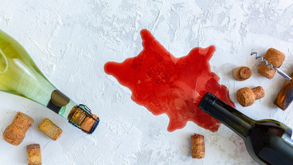 Bottles of white and red wine, corks and an old corkscrew.