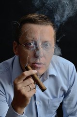 Man in blue shirt smoking cigar