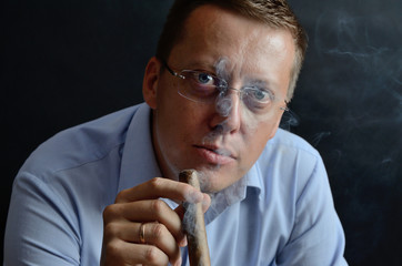 Man in blue shirt smoking cigar