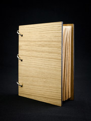 Wooden notebook on a dark background.