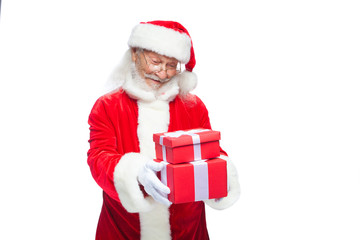 Christmas. Smiling Santa Claus in white gloves is holding two gift red boxes with a bow, one on the other. Isolated on white background.