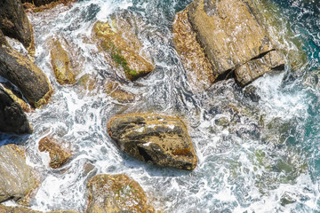 Rocks in the blue Mediterranean Sea on a bright sunny day.