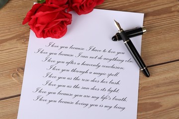 
love letter - handwritten letter with a declaration of love with red roses on a wooden table -...