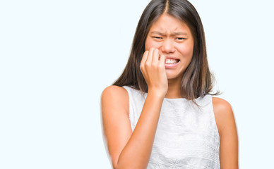 Fototapeta premium Young asian woman over isolated background looking stressed and nervous with hands on mouth biting nails. Anxiety problem.