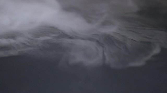 Cigarette smoke spreads on a black background