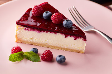 Cheesecake with berries on wooden background