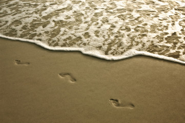 Footprints in the sand at low tide along Barefoot Beach, Florida.