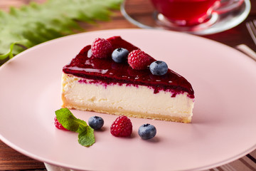 Cheesecake with berries on wooden background