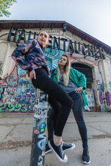 Berlin, Germany - May 5 , 2018 : young girls are posing in front of graffiti walls in popular party area Warschauer Strasse