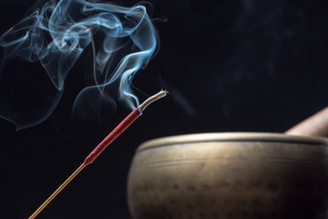 Tibetan singing bowl and incense sticks burning with smoke
