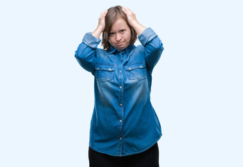 Young adult woman with down syndrome over isolated background suffering from headache desperate and stressed because pain and migraine. Hands on head.