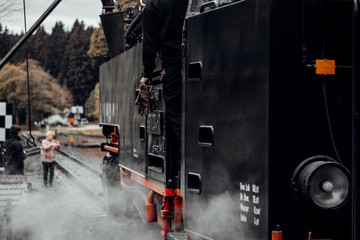 Lokführer steigt ins Führerhaus der Dampfeisenbahn ein