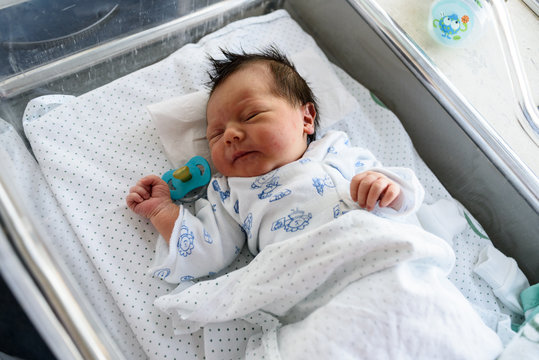 Bebé recién nacido en cuna de hospital 26
