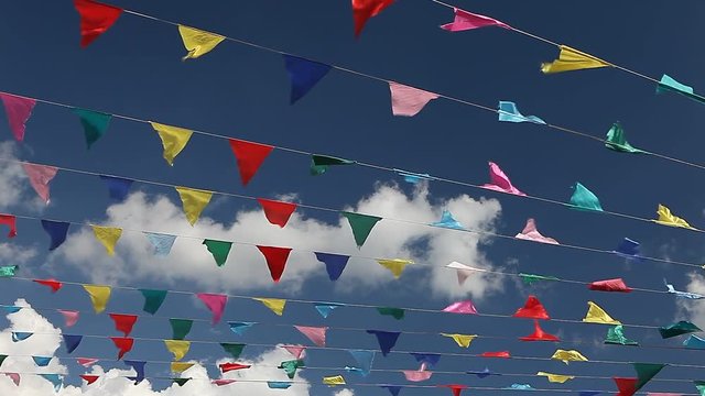 Carnival celebrate banner party flags against cloudy blue sky on windy day