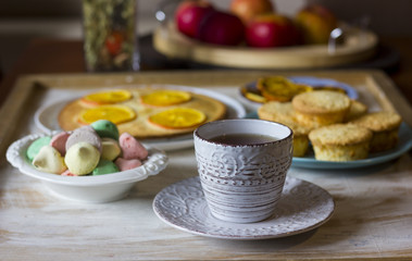 Tea with orange tarts and muffins
