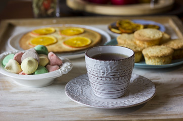 Tea with orange tarts and muffins
