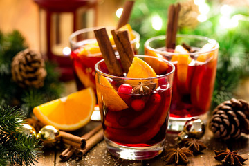 Christmas mulled red wine with spices and oranges on a wooden rustic table. Traditional hot drink...