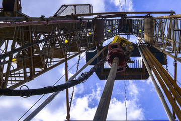 Oil and Gas Drilling Rig onshore dessert with dramatic cloudscape. Oil drilling rig operation on the oil platform in oil and gas industry.