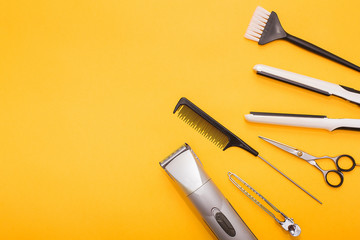 Professional hair dresser tools on yellow background with copy space
