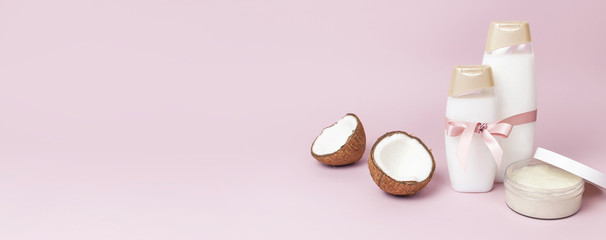 Organic cosmetics with shower gel, ripe coconut on pink colored background minimal flat lay style. Coconut oil, milk. Healthy skincare. Homemade cosmetic for peeling and spa concept.