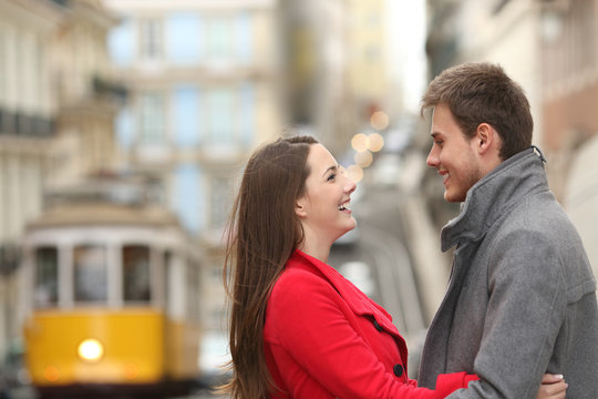 Cheerful couple looking each other in the street