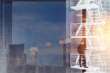 Man standing on fire escape stairs, black wall
