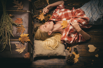 Fototapeta na wymiar Girl in autumn in a seasonal clothes whith golden leaf. Autumn concept. Beautiful girl on wood background board for Copyspace. Having fun.