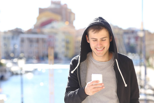 Teen using a smart phone in a coast town street