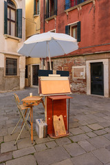 An artist's easel, pallet, chair and stand in Venice, Italy.