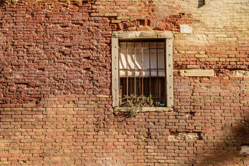 A rustic brick wall and window of a propertry in Venice, Italy.