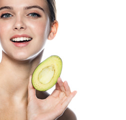 portrait of attractive young caucasian smiling cheerful woman isolated on white studio shot eating avocado lookıng at camera toothy smıle
