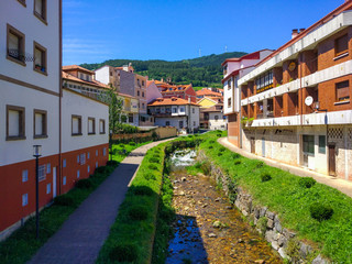Fototapeta na wymiar View of a canal with Nonaya river flowing down and buildings at the sides in Salas, Asturias, Spain