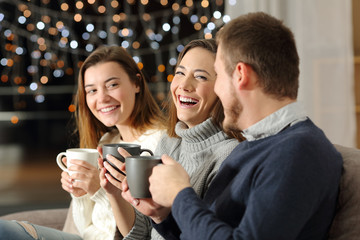 Three friends talking and laughing in the night at home