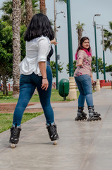 Two chubby girls with inline skates in the park happy