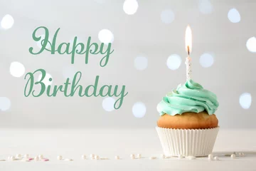 Foto op Plexiglas Delicious cupcake with burning candle and greeting HAPPY BIRTHDAY on blurred lights background © New Africa