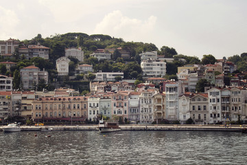 View of motorboats and yachts, buildings on European side and Bosphorus in Istanbul. It is a sunny summer day.