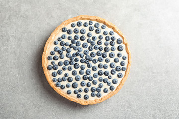 Tasty blueberry cake on gray background, top view