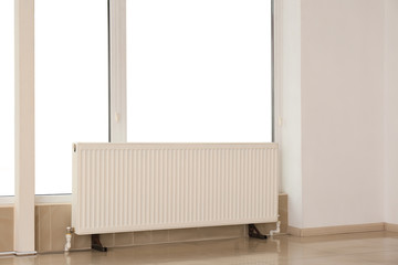Heating radiator in room against large window