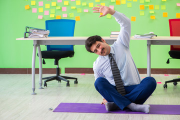 Man in the office with many conflicting priorities doing exercis