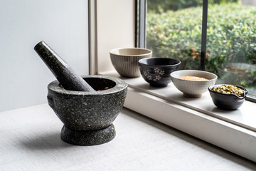 Granite pestle and mortar with japanese bowls in window - obrazy, fototapety, plakaty