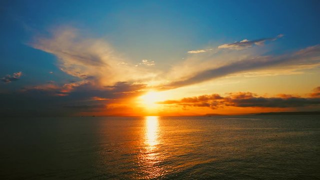 Sea view on a pleasant summer evening: a beautiful sunset, colored clouds, a pure sea with a yacht, the glint of the sun on the water. Sea, ocean, natural video for tourist, resort and meditative site