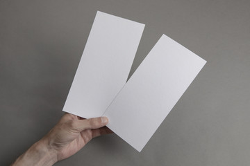 Mens hand holding white flyers