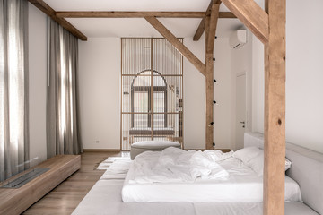 Stylish bedroom in modern style with wooden beams