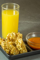 traditional Brazilian bolinhos de arroz (rice balls), similar to arancini with orange juice and peper