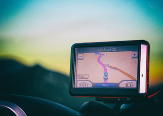 Red GPS equipment showing the route to the destination with out of focus mountains on the...