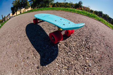 Blue plastic skateboard penny board with pink wheels.